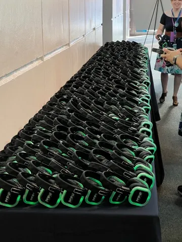 A long distribution table stacked with silent-disco headsets ready for guest pickup